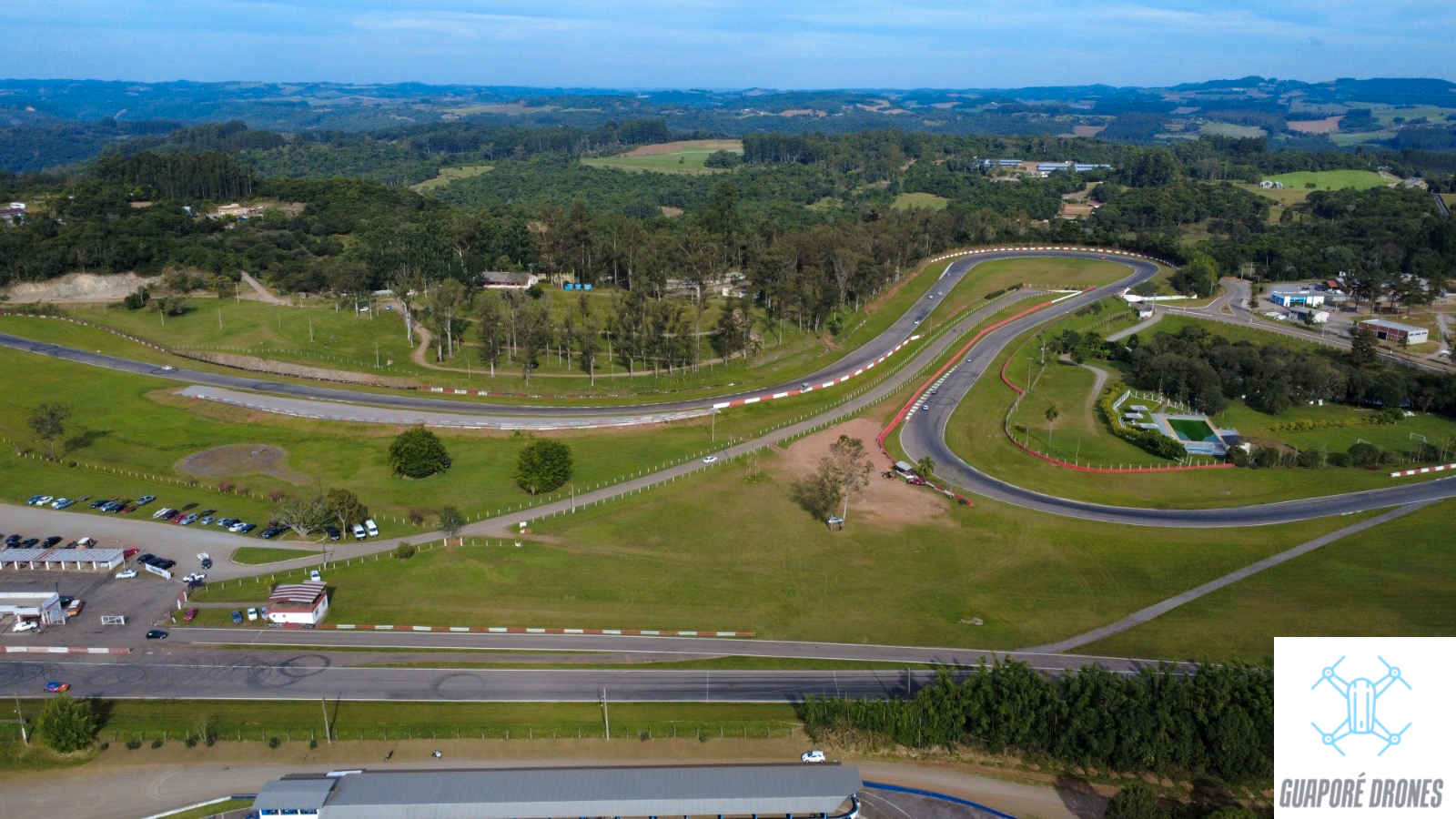 Vista aérea do autódromo de Guaporé com carros de corrida na pista e zebras vermelhas e brancas