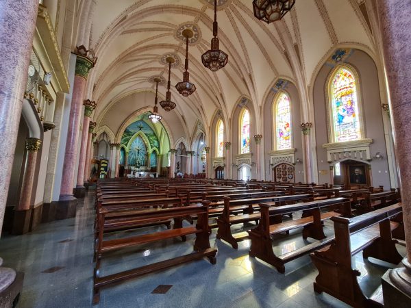 Interior da Igreja Matriz com bancos de madeira e vitrais