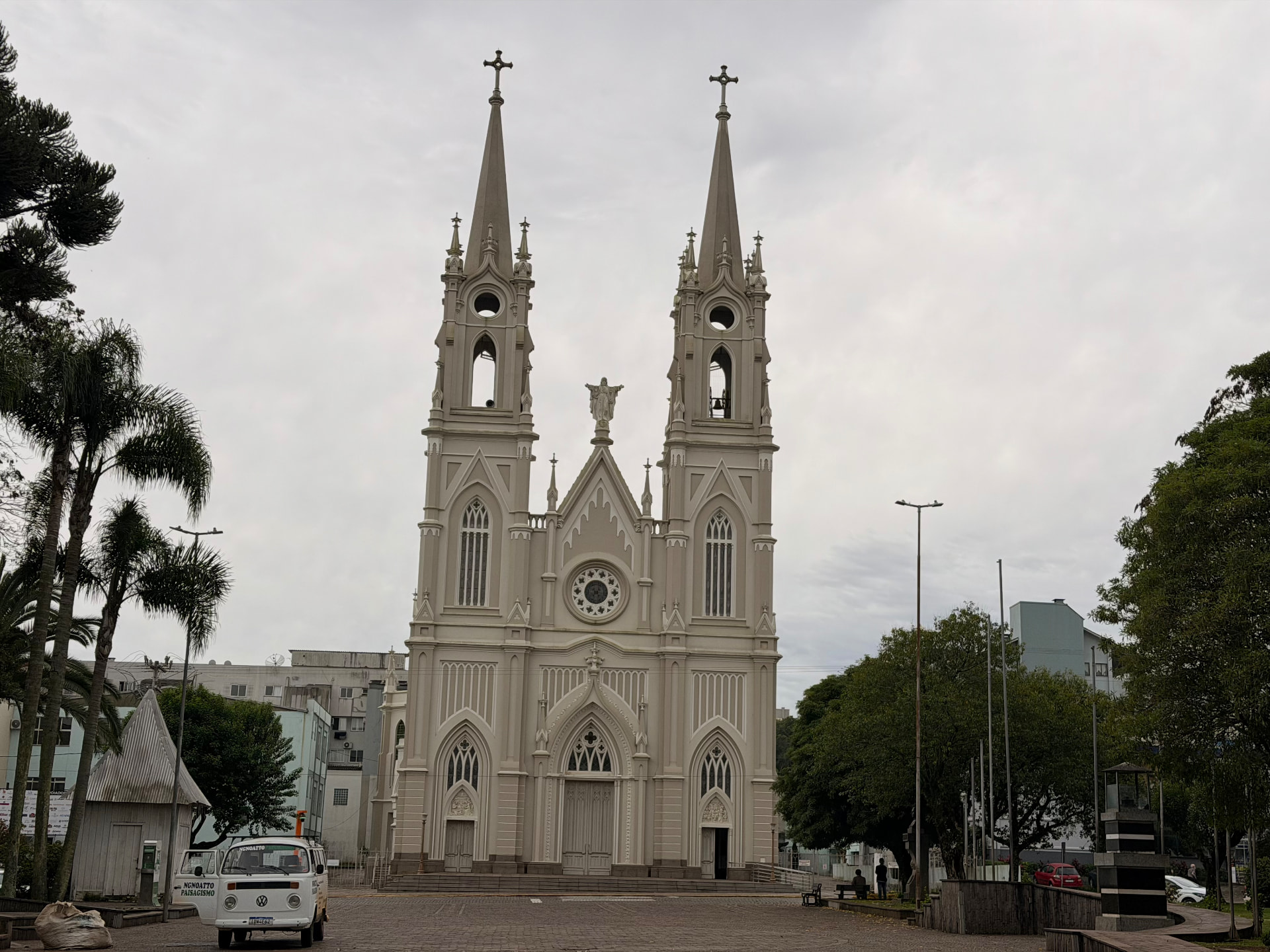 Fachada da Igreja Matriz Santo Antônio vista da praça, com pessoas e bancos em primeiro plano