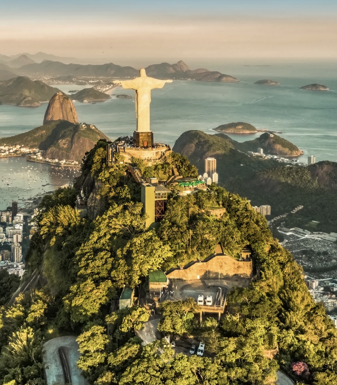 Rio de Janeiro: vista aérea do Cristo Redentor no Corcovado, com o Pão de Açúcar, a Baía de Guanabara e a mata do morro em primeiro plano